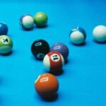 A dynamic close-up shot of colorful billiard balls on a blue pool table, adding vibrancy to any space.