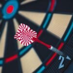 A dart striking the bullseye on a dartboard, showcasing precision and accuracy.
